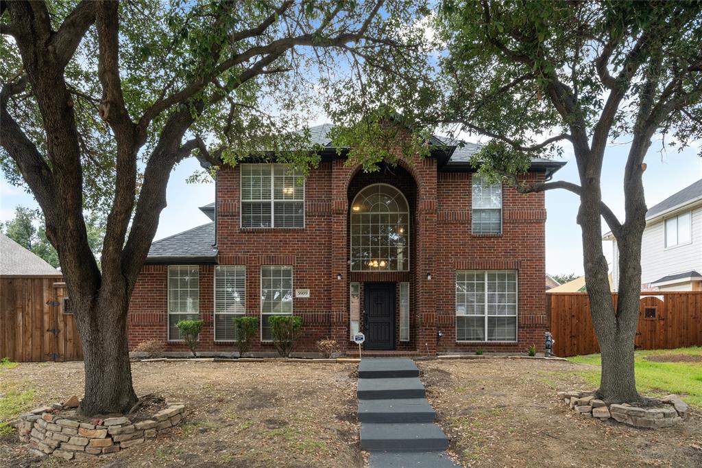 a front view of a house with a tree