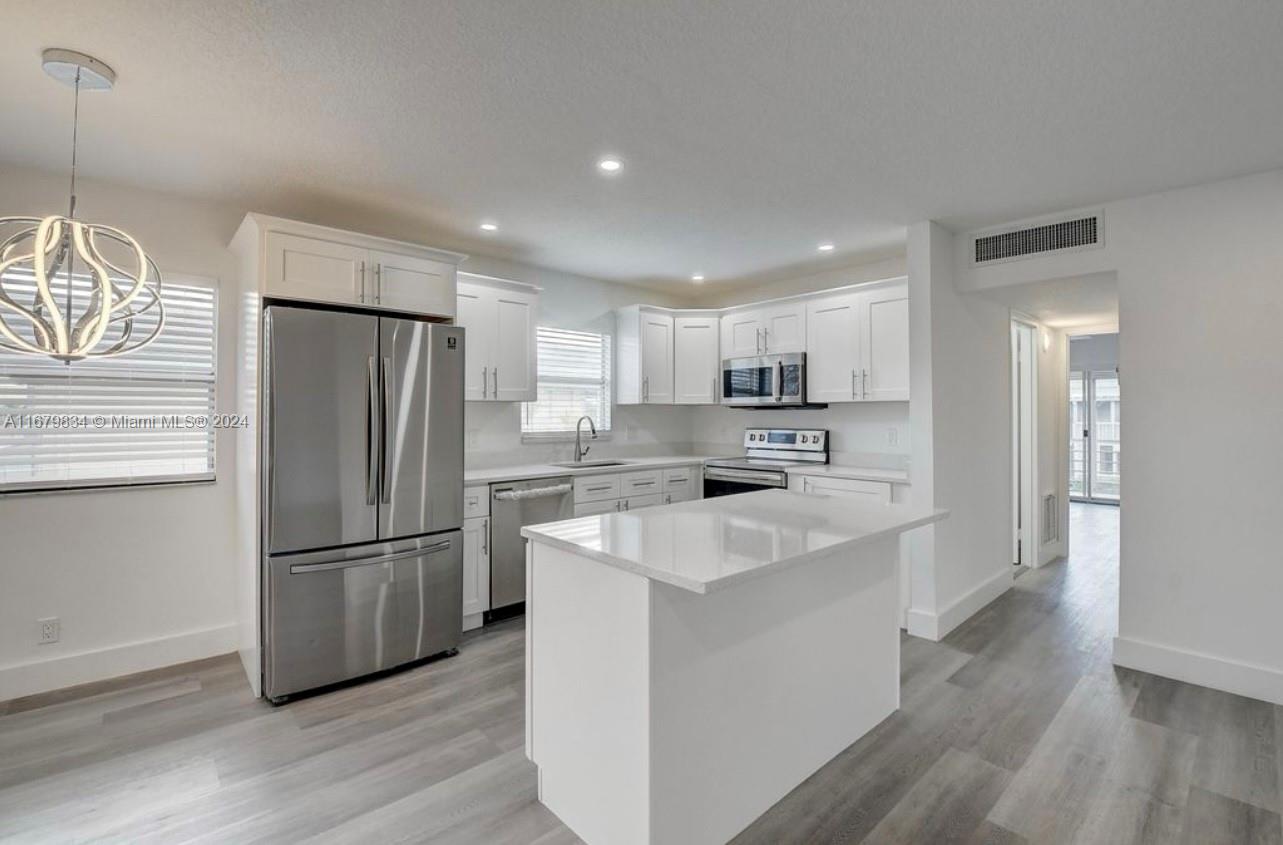 a kitchen with stainless steel appliances a refrigerator sink and microwave