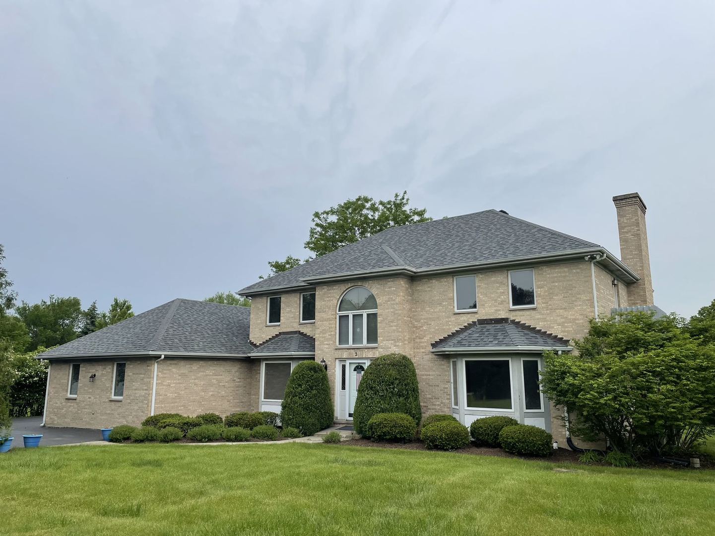 a front view of a house with a yard and trees