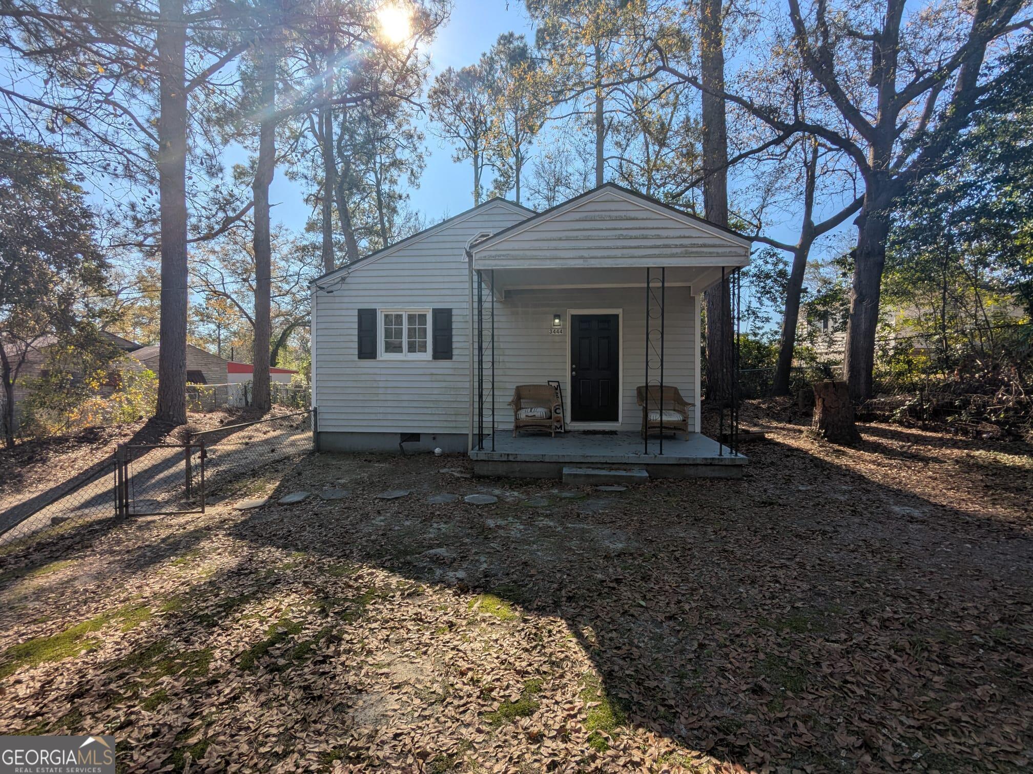 a view of a house with a yard and large tree