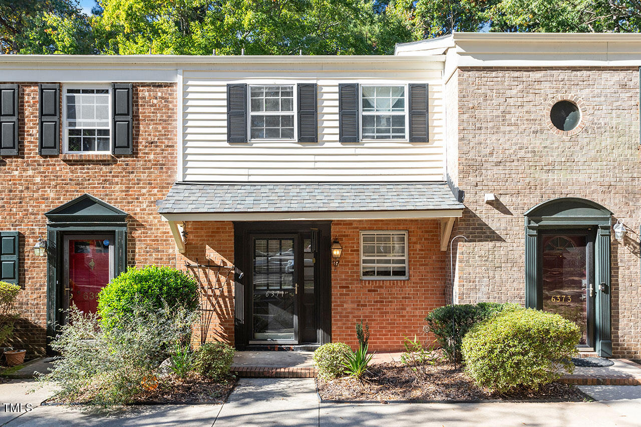 front view of a brick house with a small yard