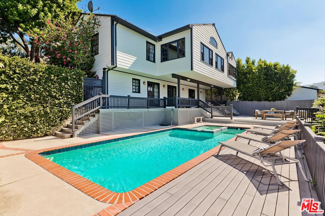 a front view of a house with swimming pool and porch