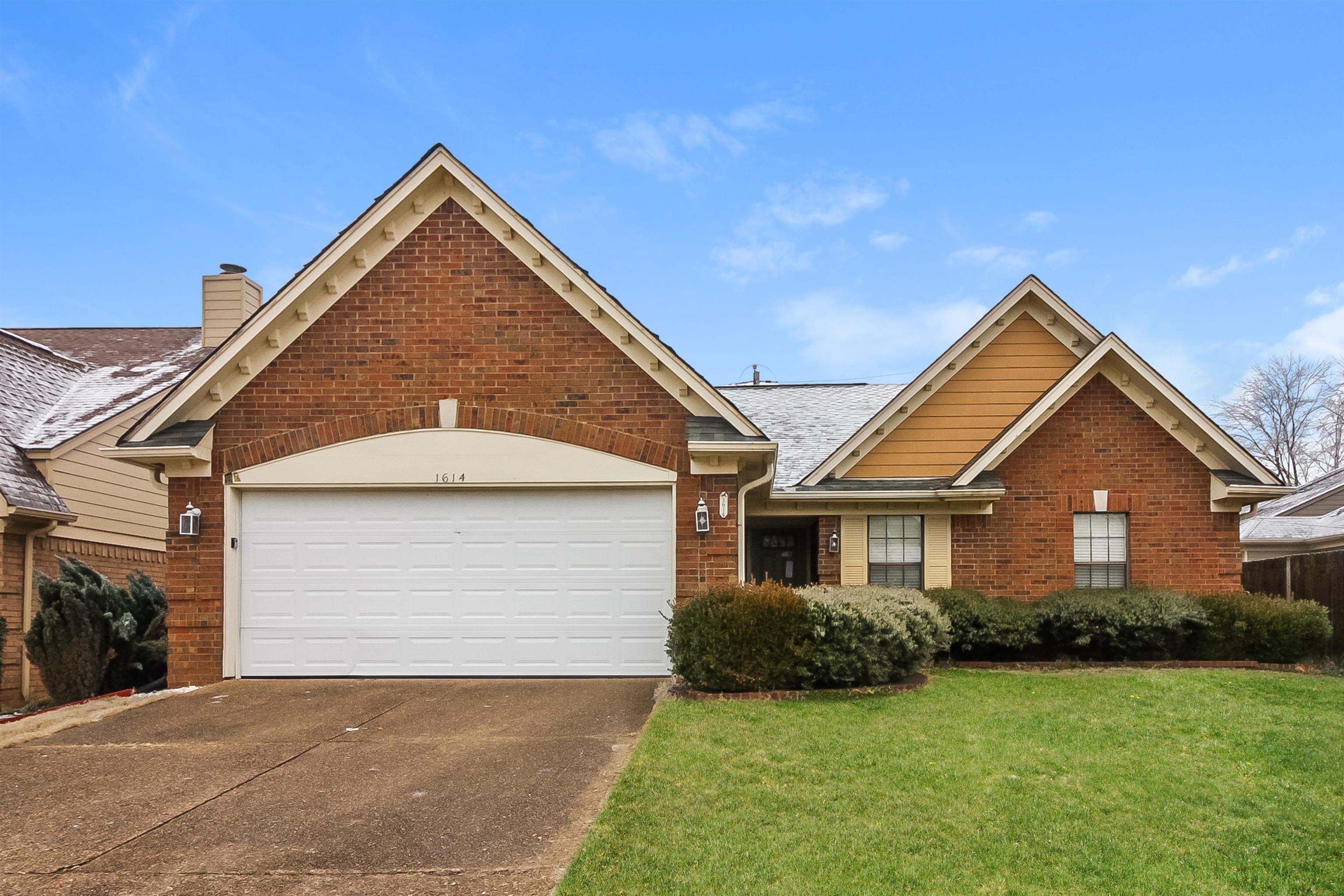 View of front of home with a front lawn and a garage