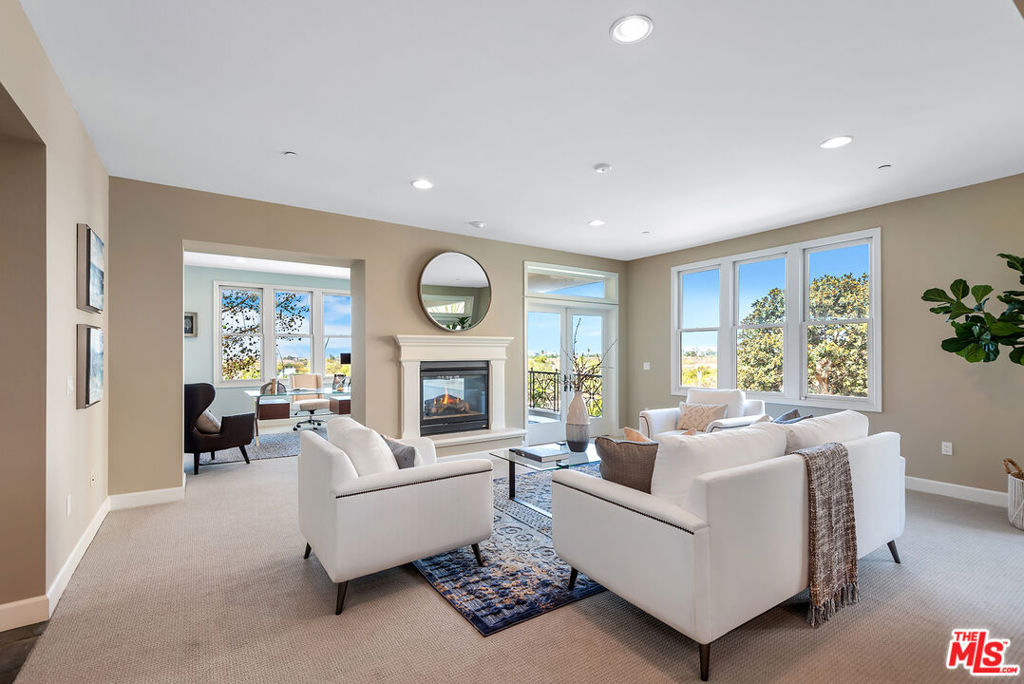 a living room with furniture a fireplace and a large window