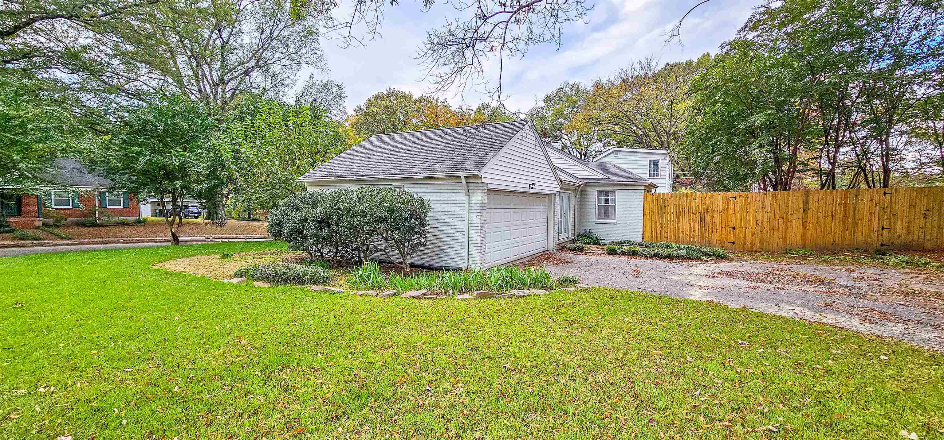 a front view of a house with a garden and yard