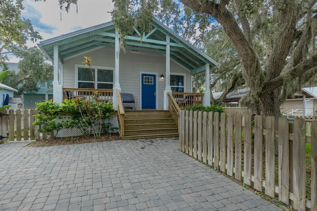 a view of a house with wooden fence next to a yard