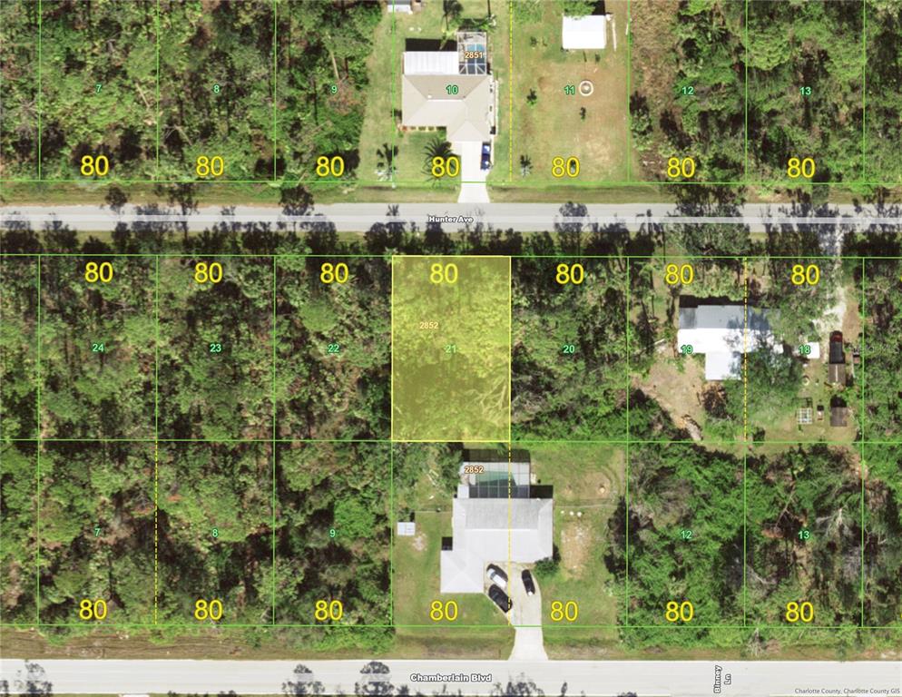 an aerial view of ocean with residential house with outdoor space and trees all around