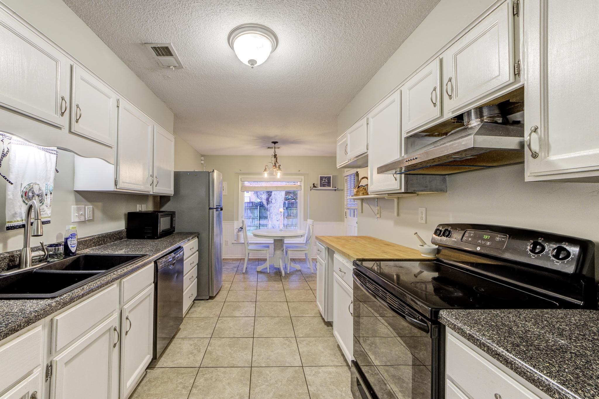 a kitchen with a sink a stove and cabinets