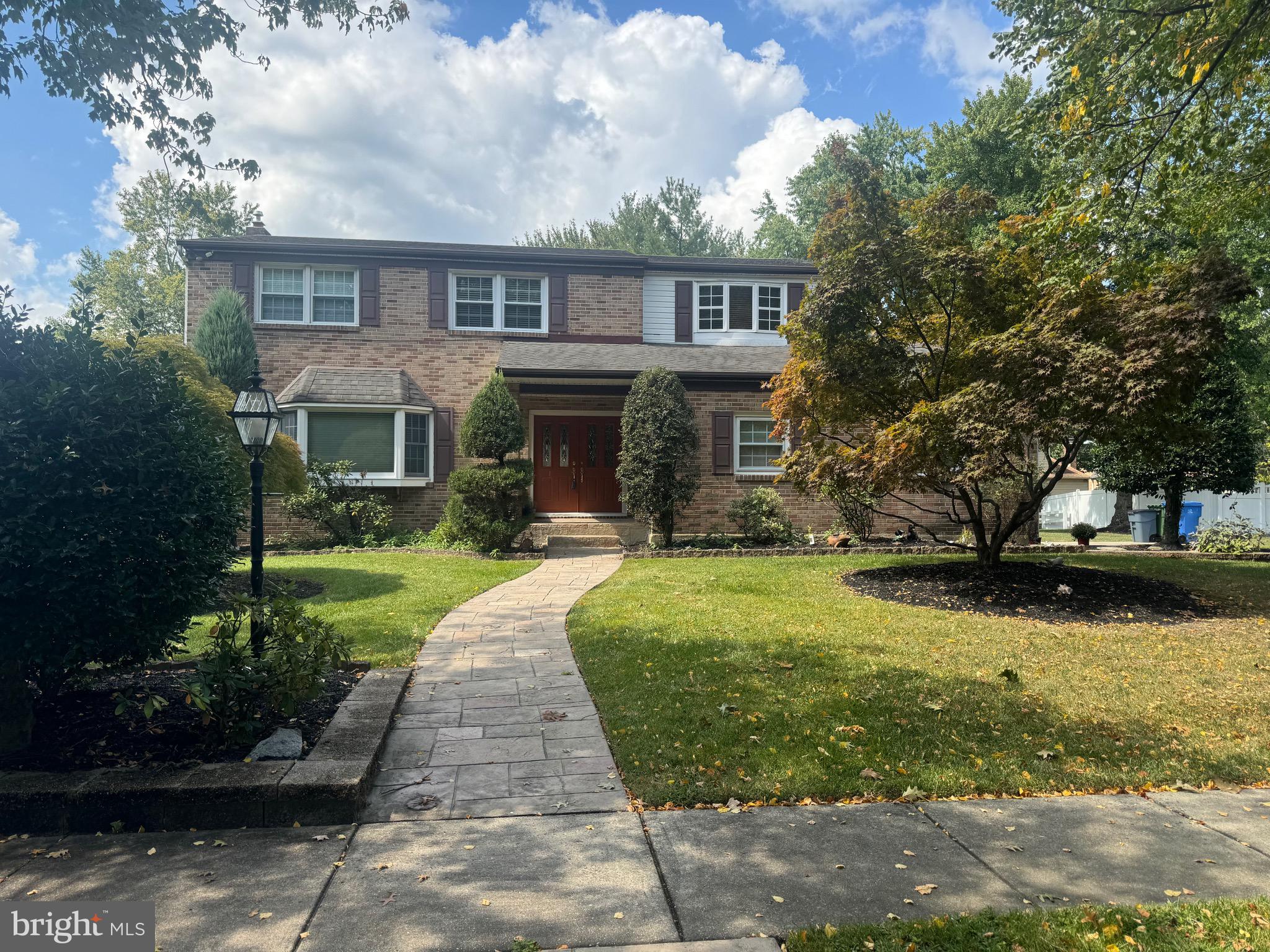 a front view of a house with a yard and a garden