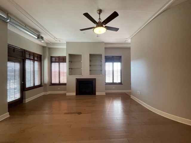 en empty room with windows and ceiling fan