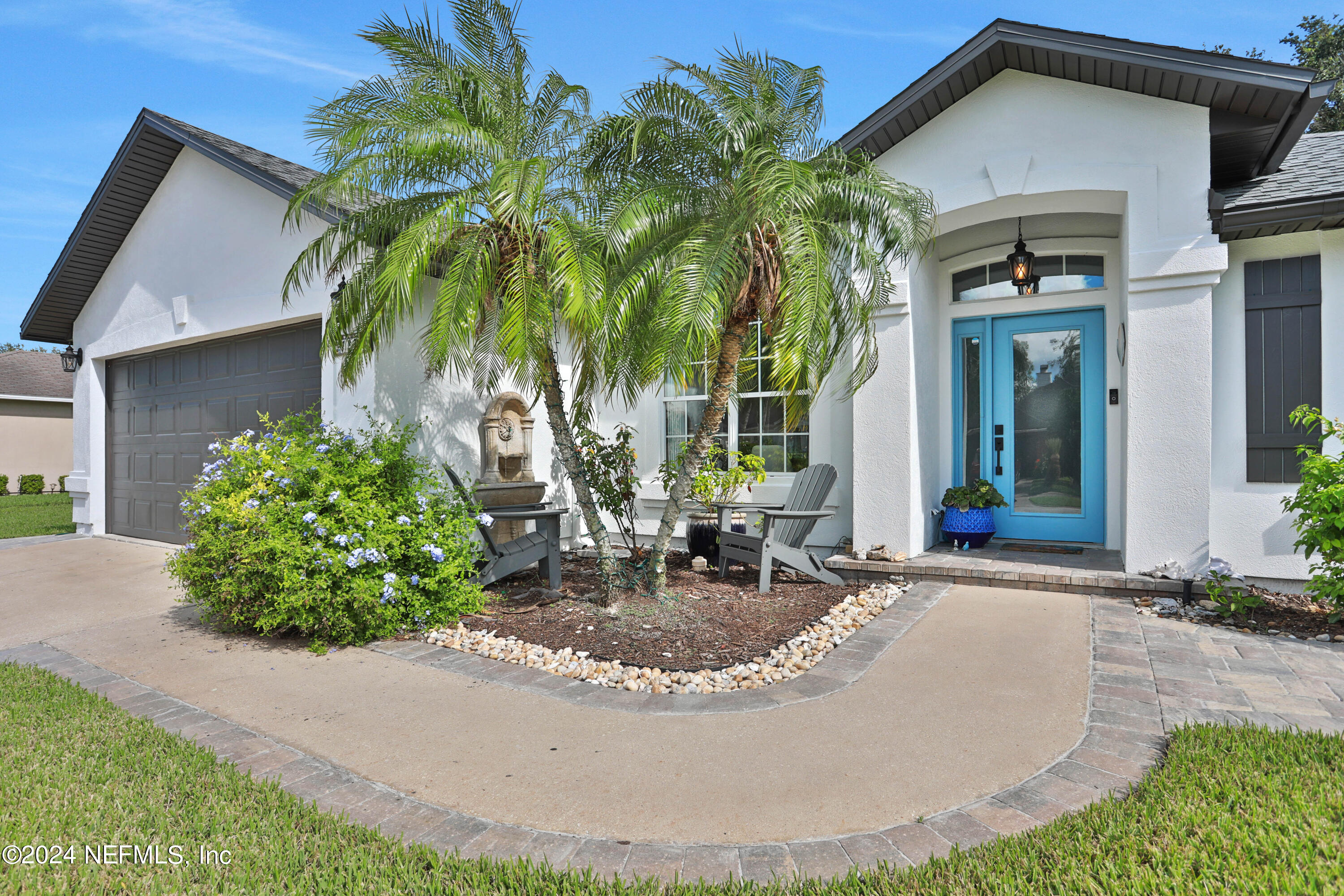 a view of a house with a small yard and a fountain