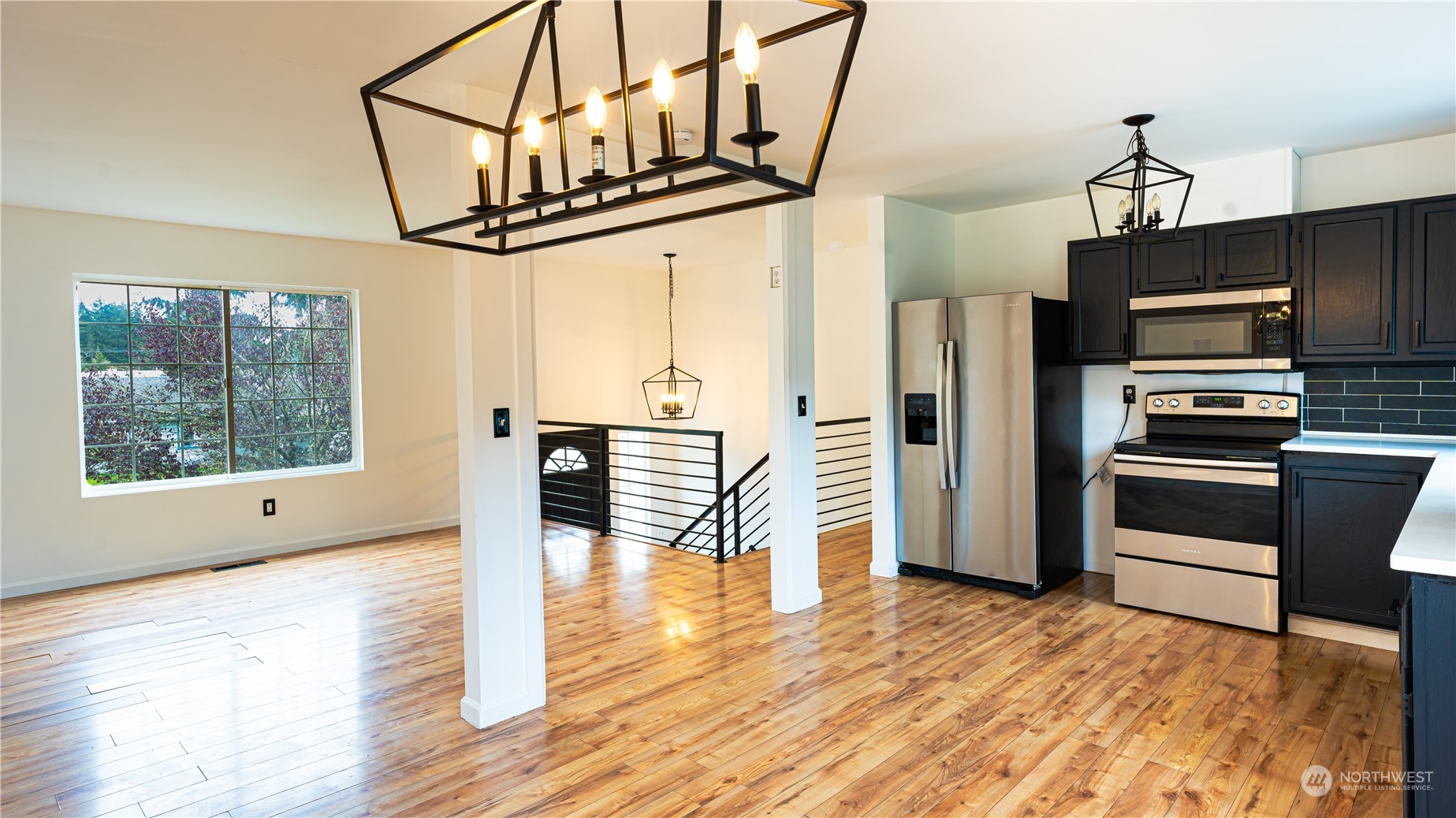 a view of a kitchen with furniture a flat screen tv and wooden floor