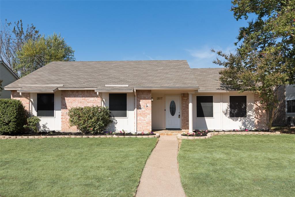 a front view of a house with a yard and trees