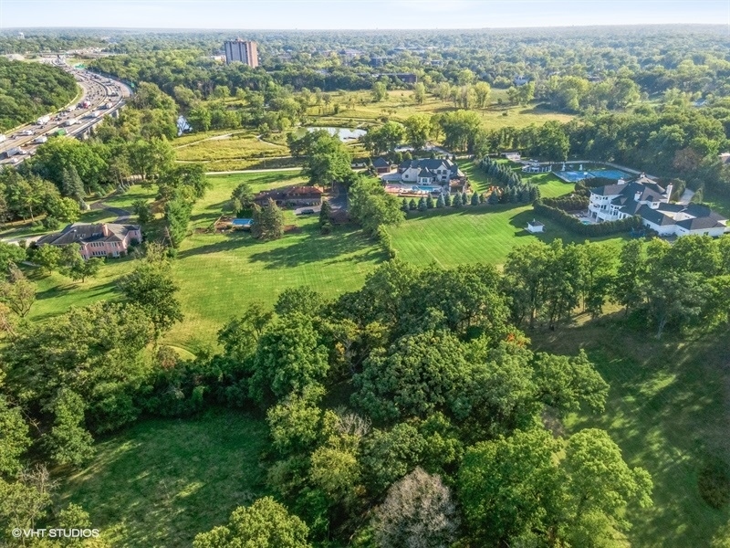 an aerial view of residential houses with outdoor space and trees