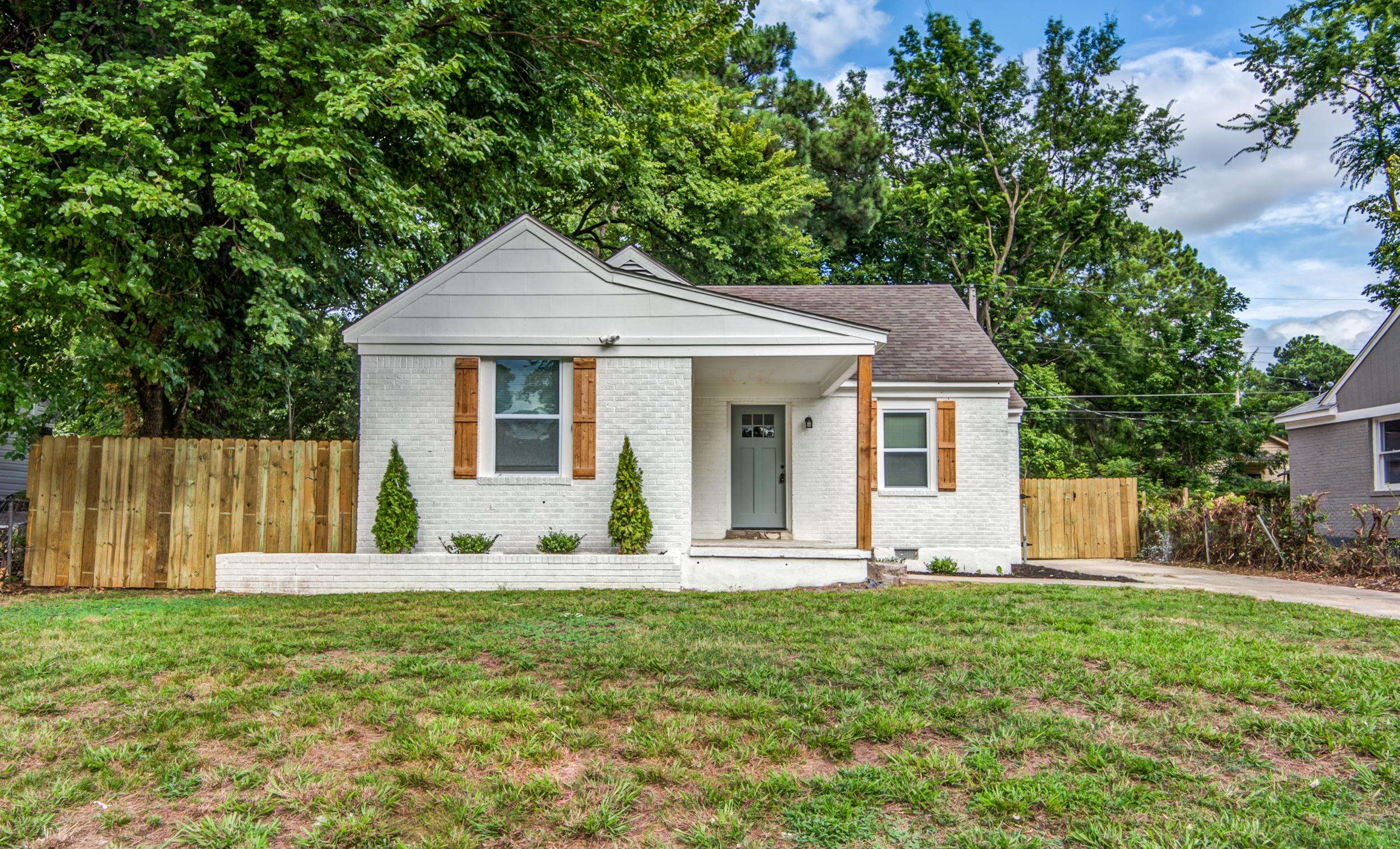 a front view of house with a garden and yard