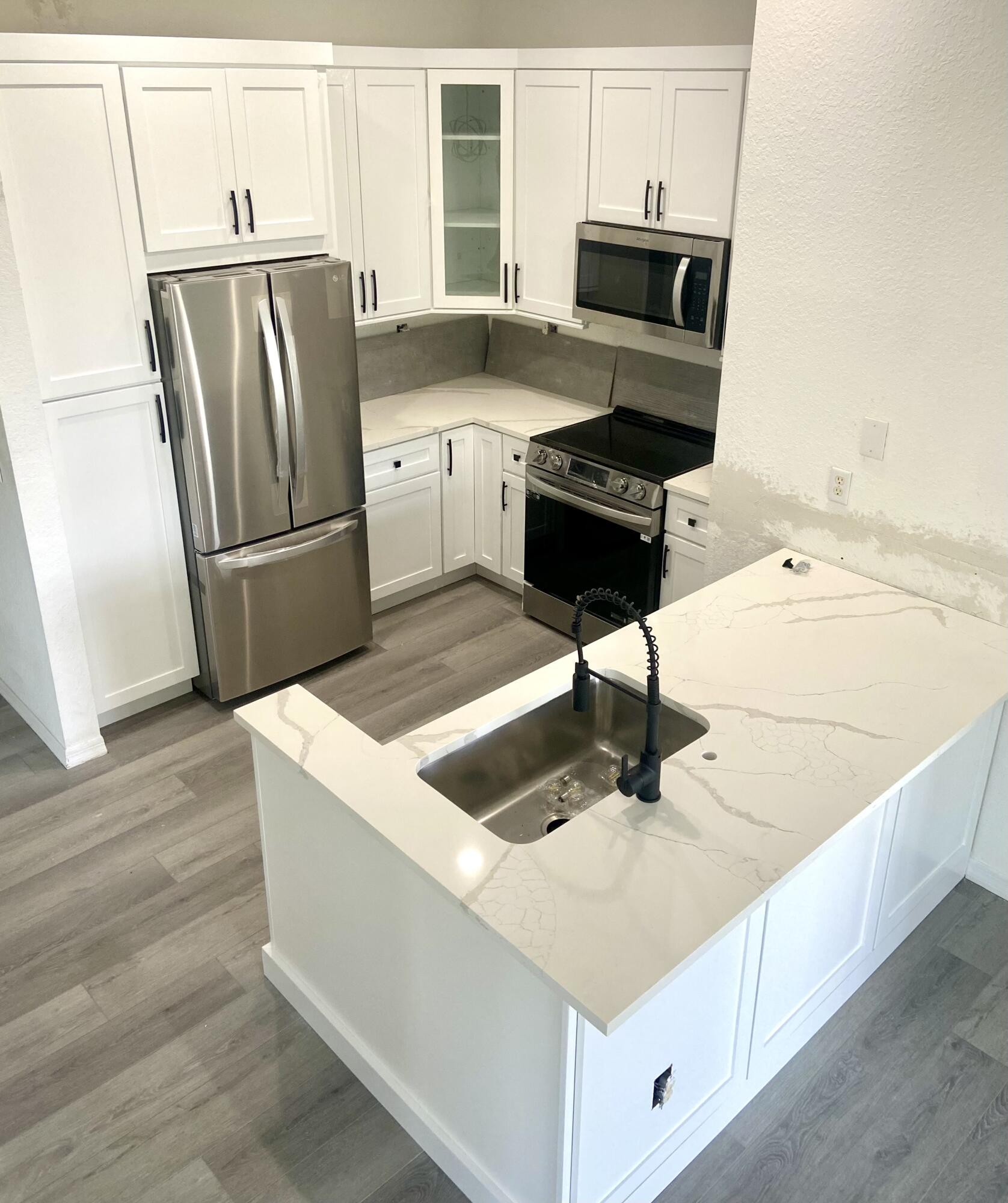 a kitchen with stainless steel appliances a refrigerator sink and stove