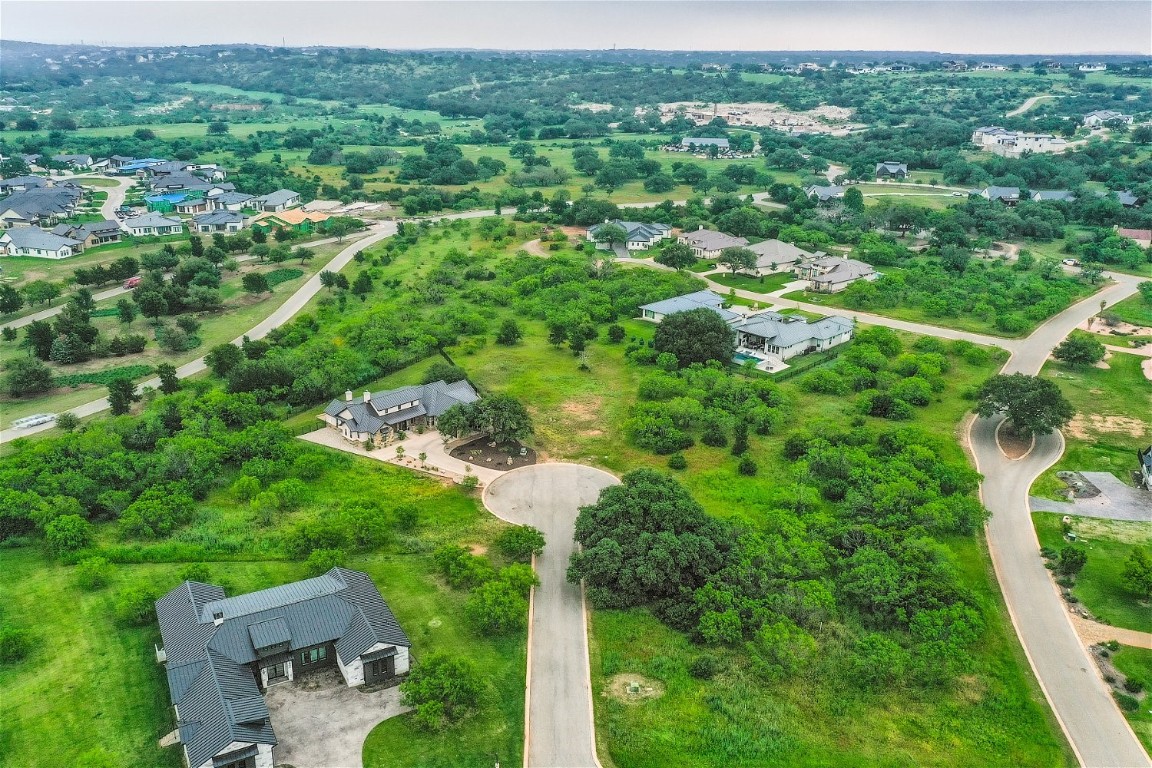 an aerial view of residential houses with outdoor space and trees