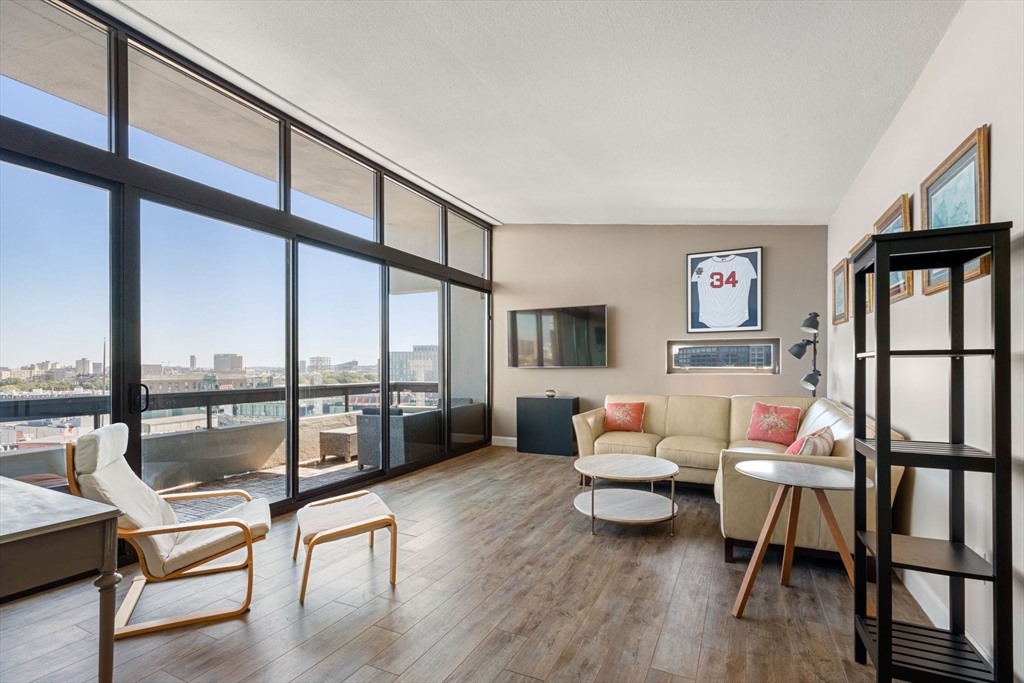 a living room with furniture wooden floor and a large window