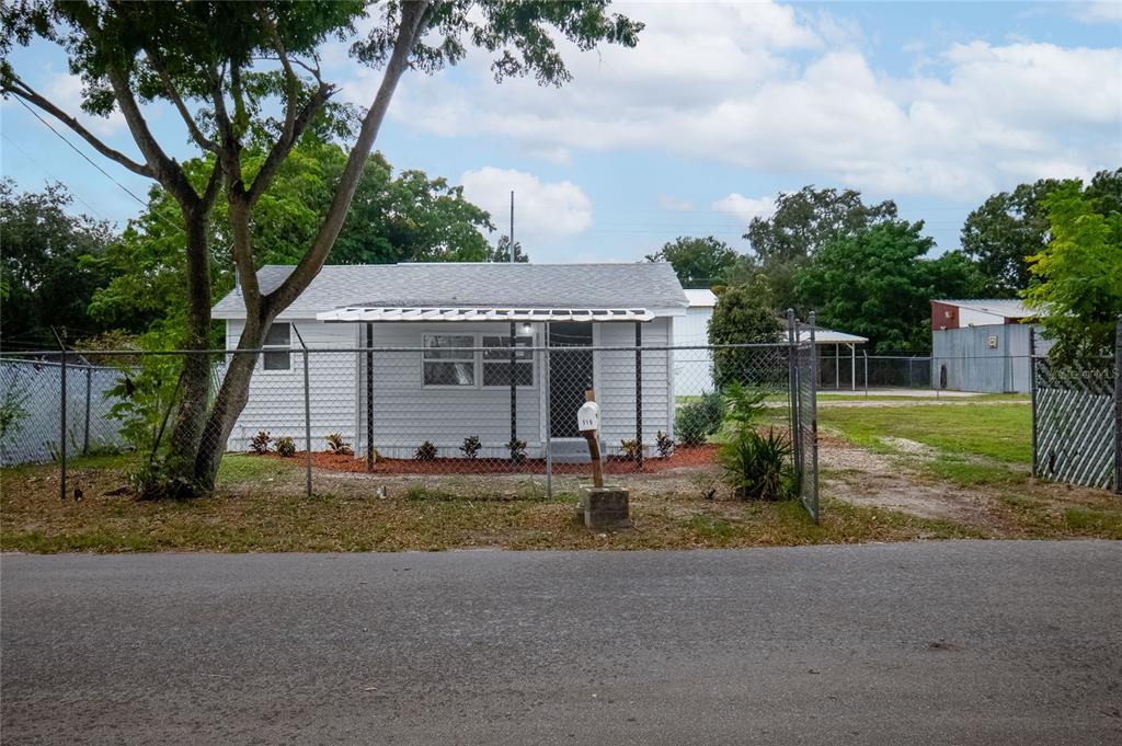 a view of a house with backyard and a tree