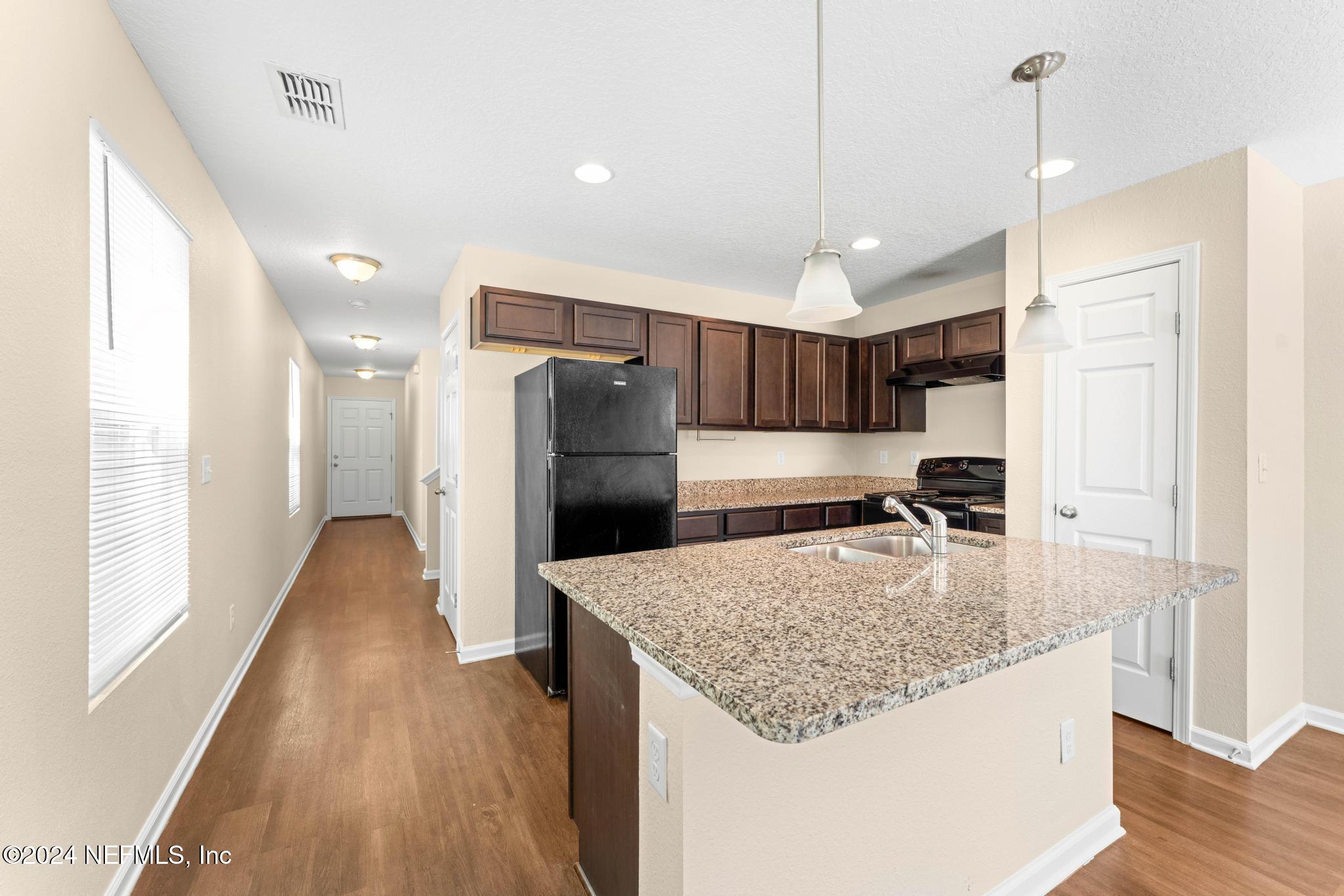 a kitchen with refrigerator and windows