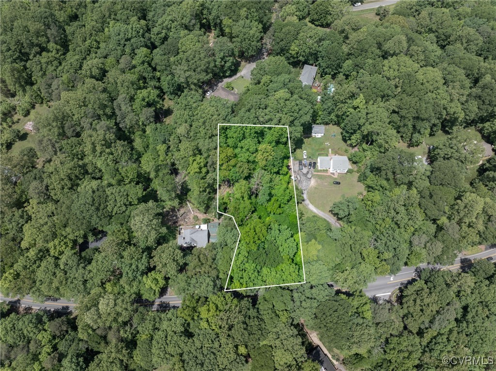 an aerial view of residential house with outdoor space and trees all around