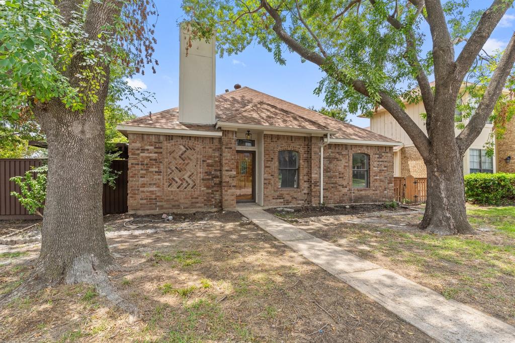 a view of a house with a tree in the yard