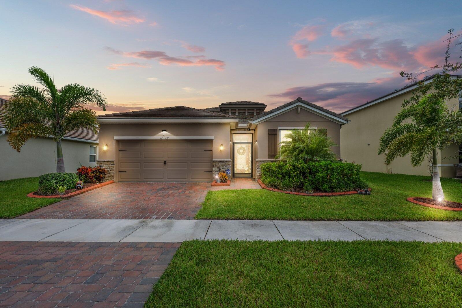 a front view of a house with a yard and garage