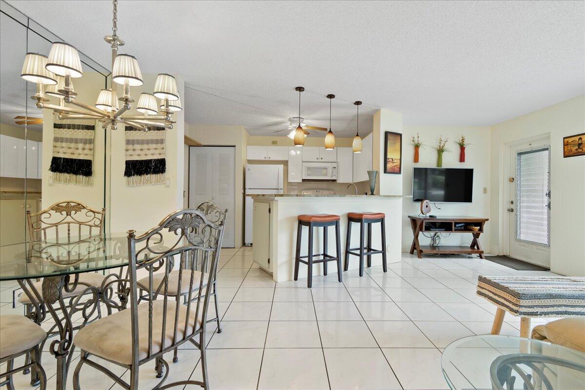 a kitchen with stainless steel appliances granite countertop a stove and a view of living room