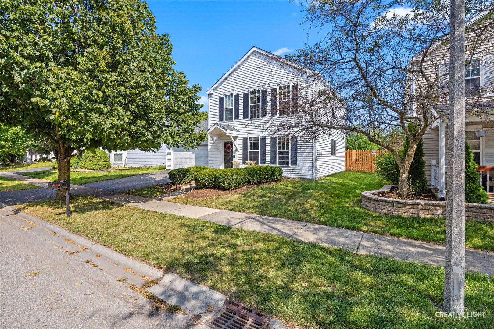 a front view of a house with yard and green space