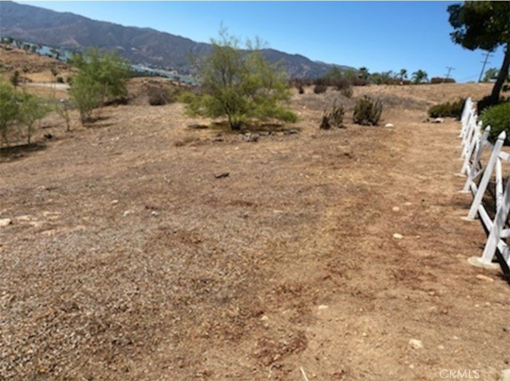 a view of a dry yard with mountains in the background