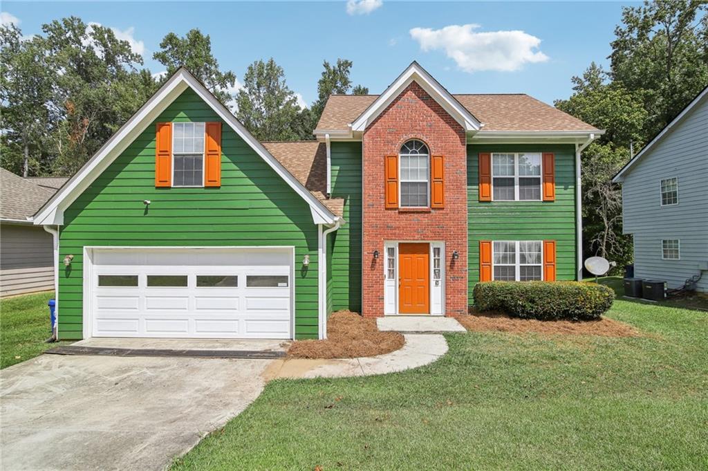 a front view of a house with a yard and garage