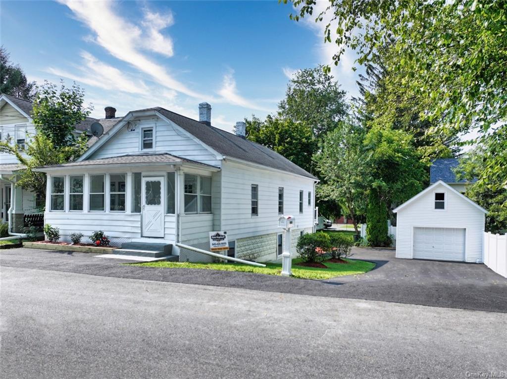 View of front of house with an outdoor structure and a garage