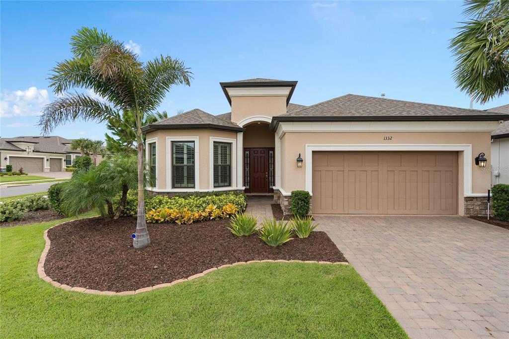 a front view of a house with a garden and yard