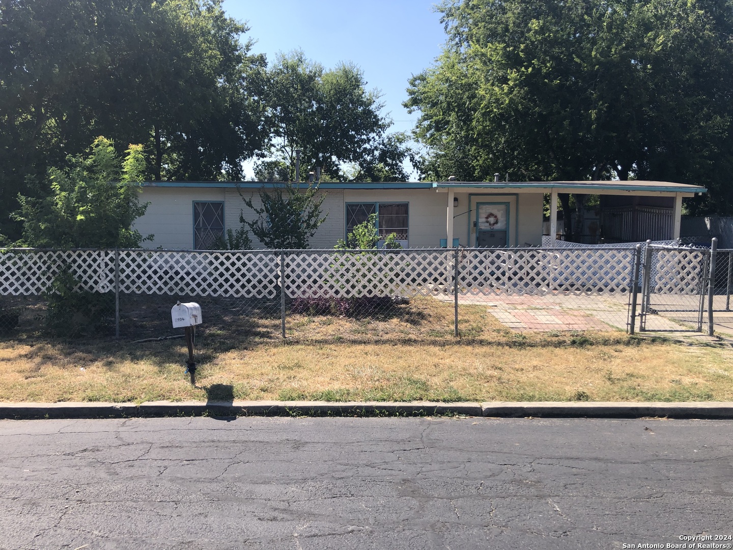 a view of a yard with a wooden fence