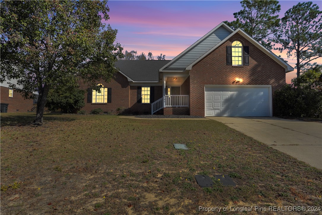 a front view of house with yard and trees in the background