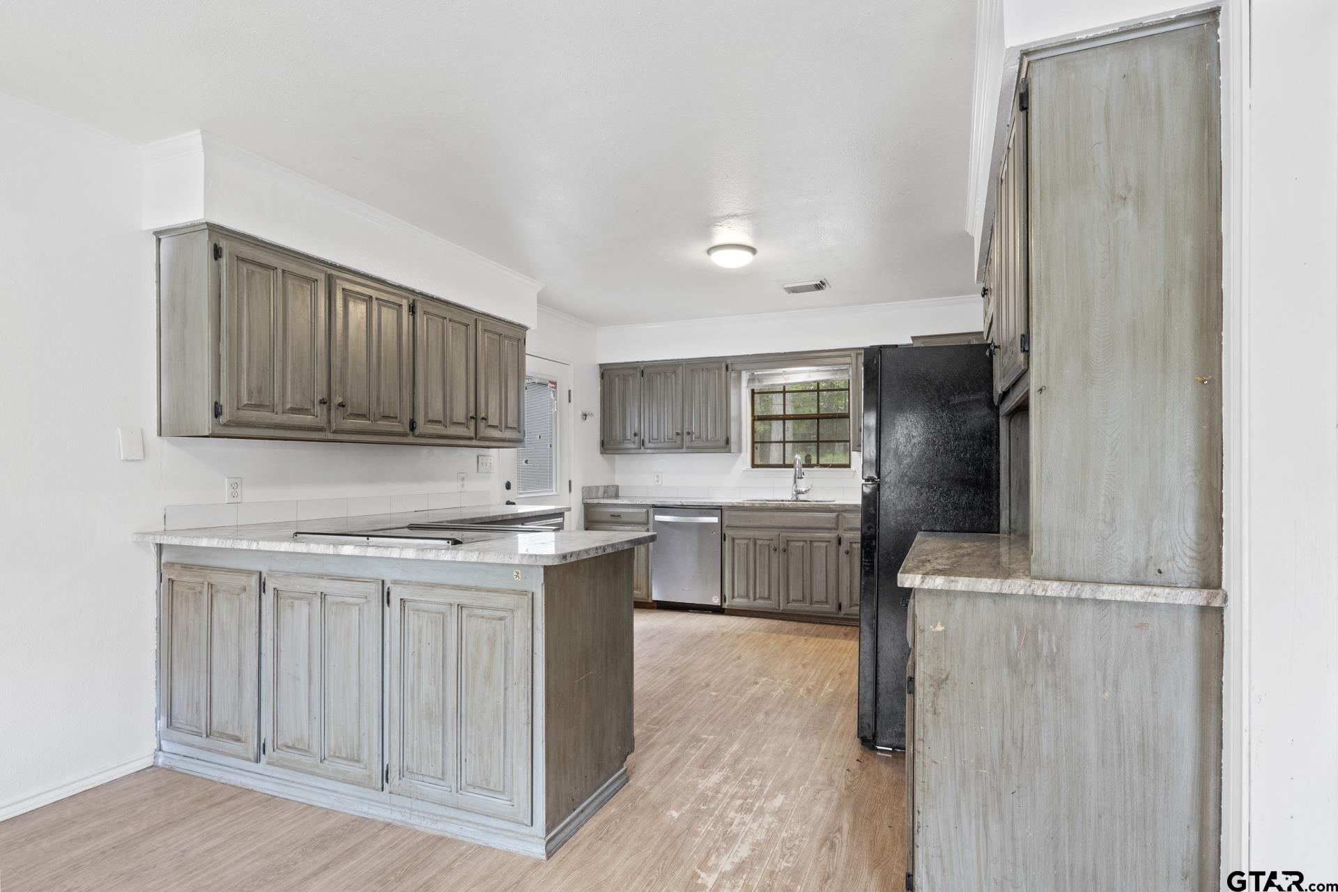 a kitchen with a refrigerator sink and cabinets