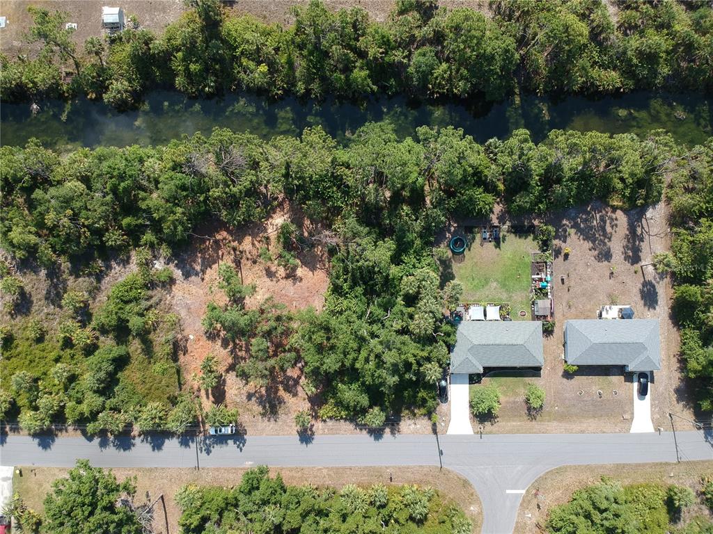 an aerial view of residential houses with outdoor space and lake view