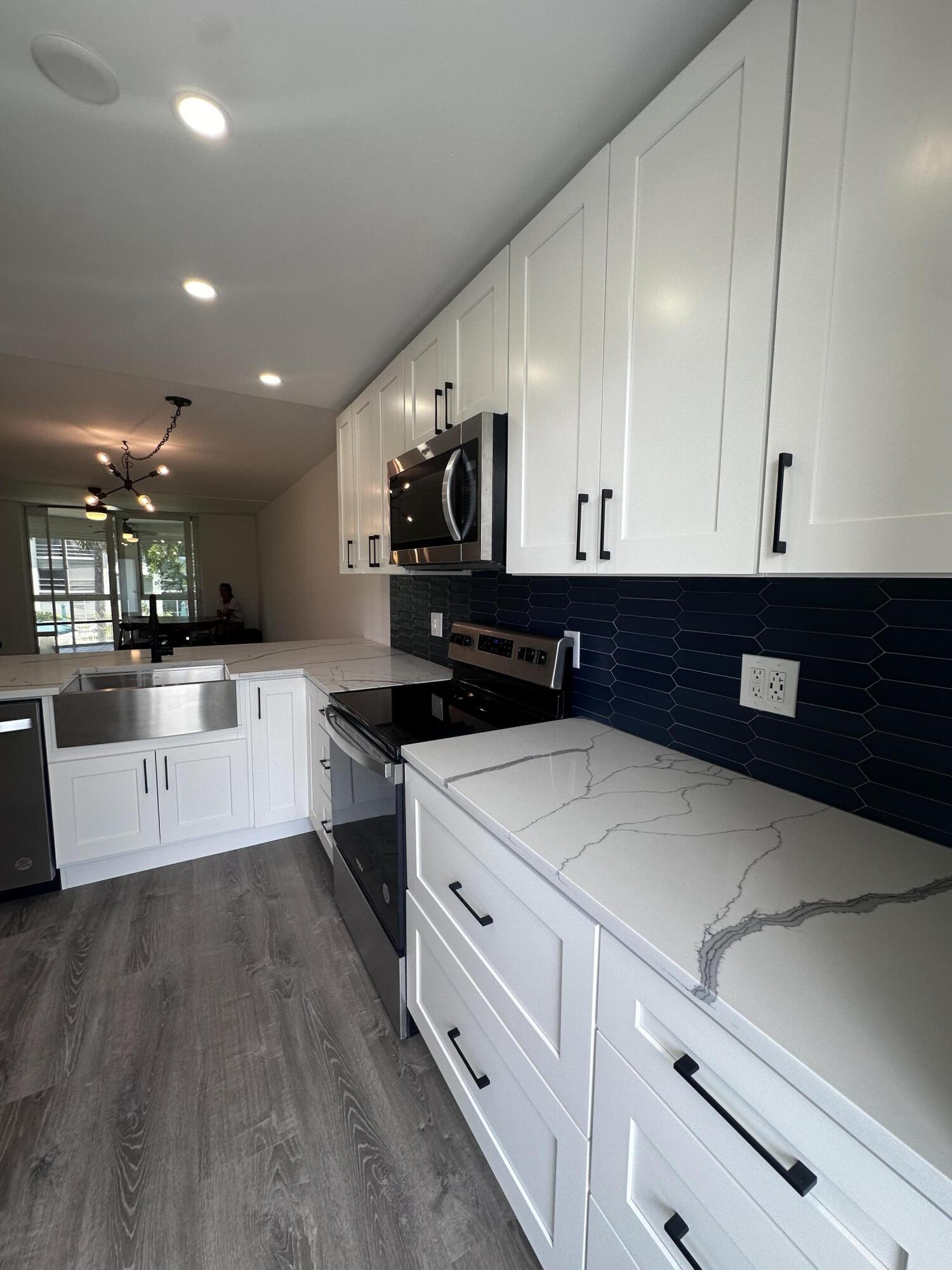 a large white kitchen with stainless steel appliances