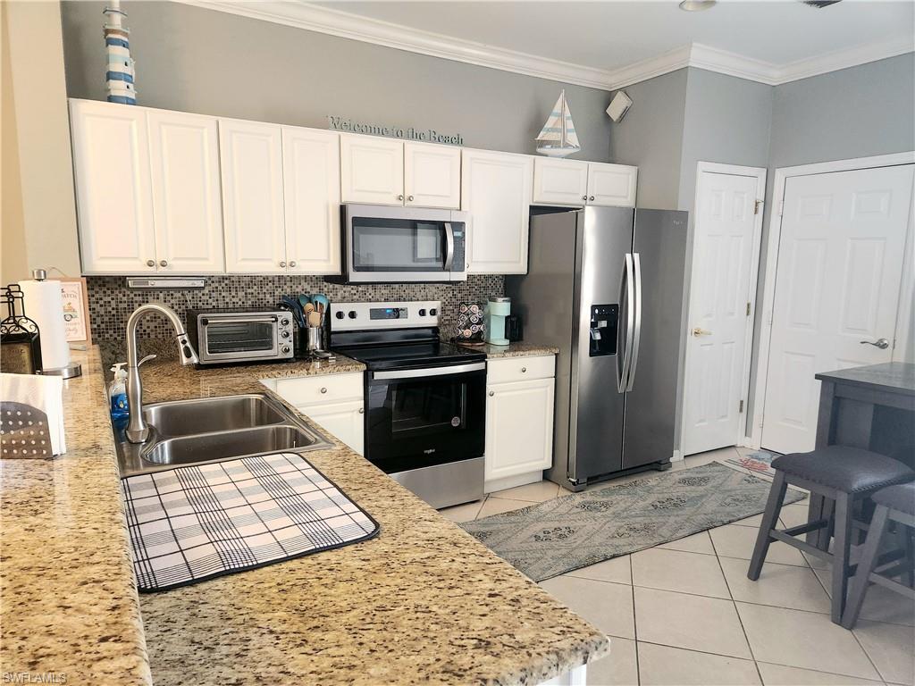 Kitchen with white cabinetry, sink, and appliances with stainless steel finishes