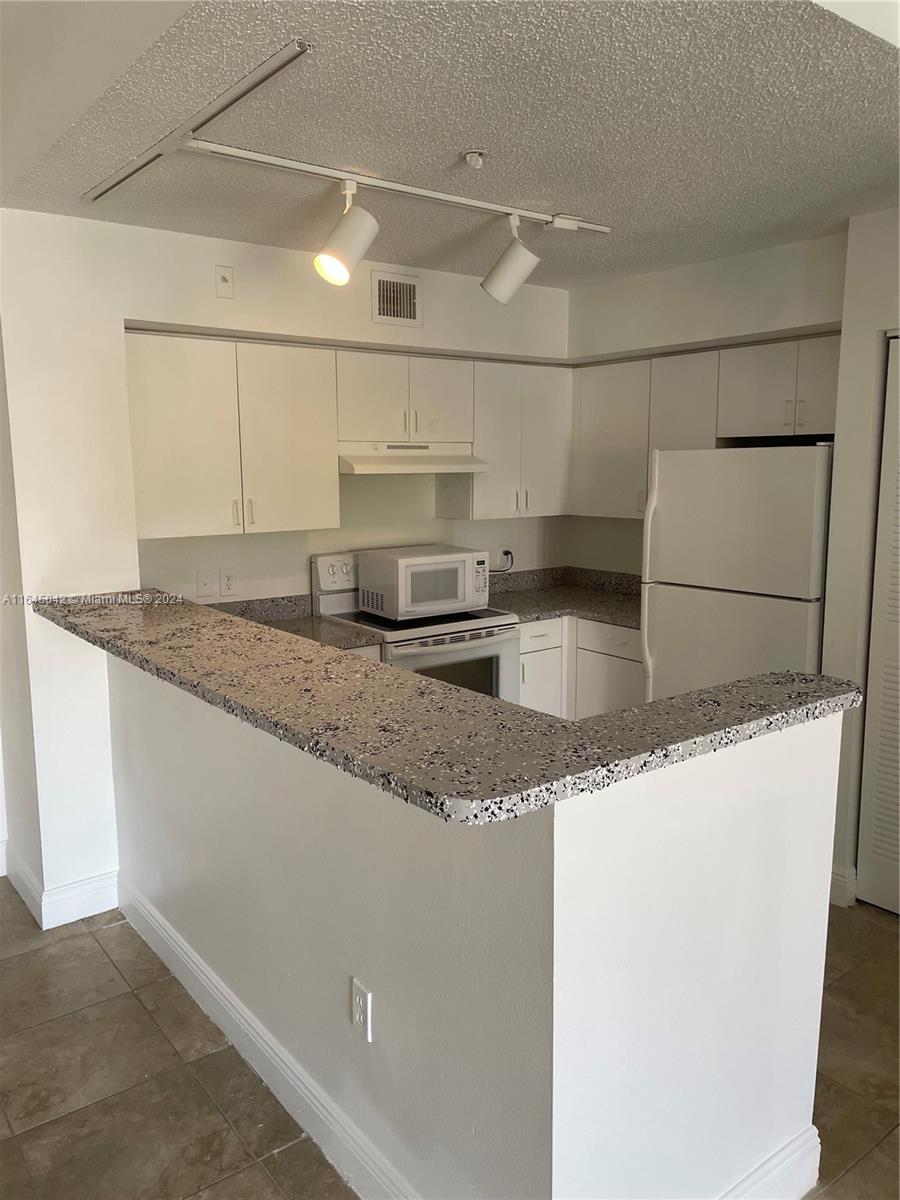 a kitchen with granite countertop a sink and a stove top oven