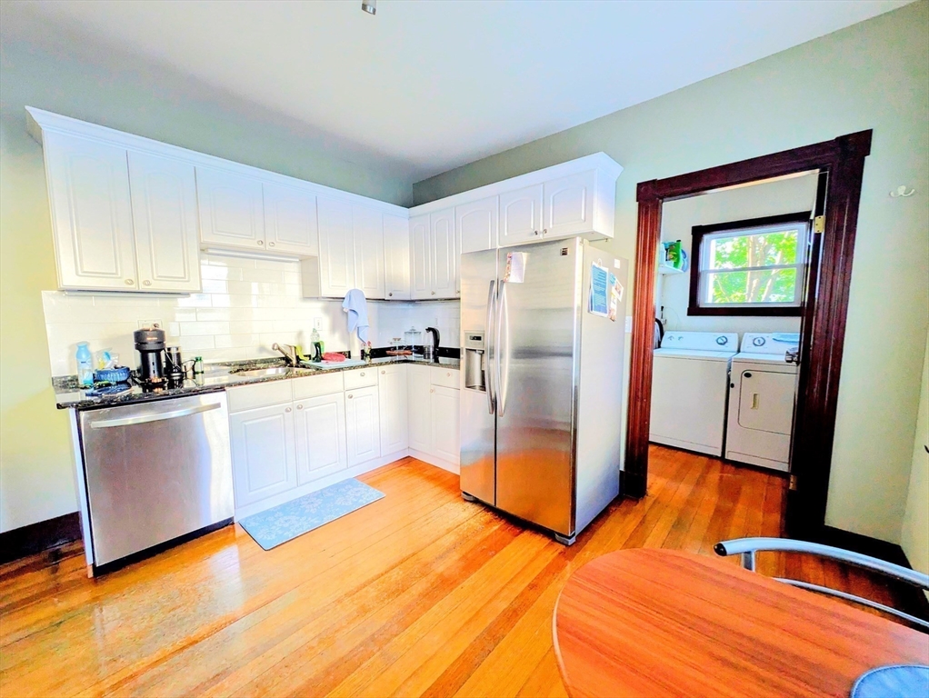 a kitchen with stainless steel appliances granite countertop a refrigerator a stove and a sink