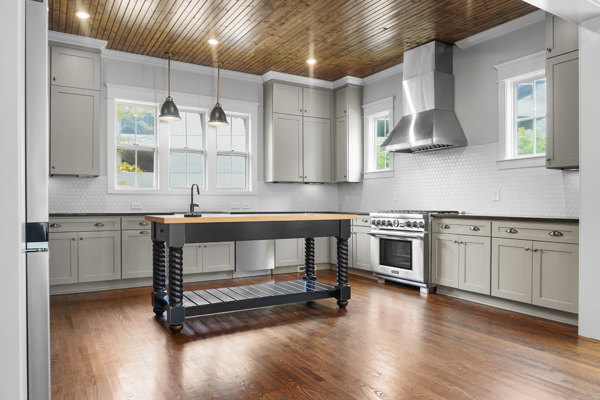 a kitchen with cabinets wooden floor and stainless steel appliances