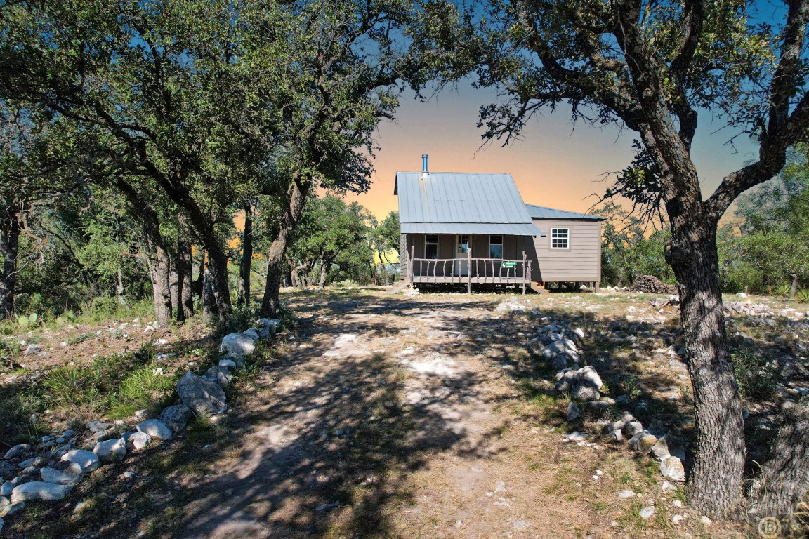 a front view of a house with a tree