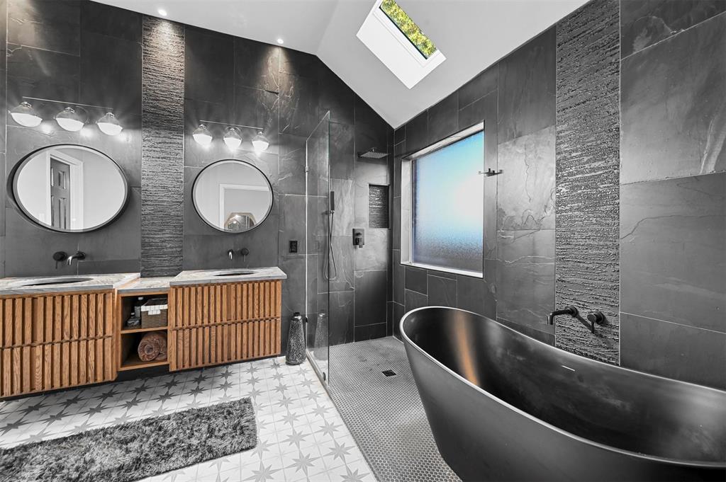 a bathroom with a double vanity sink a mirror and bathtub