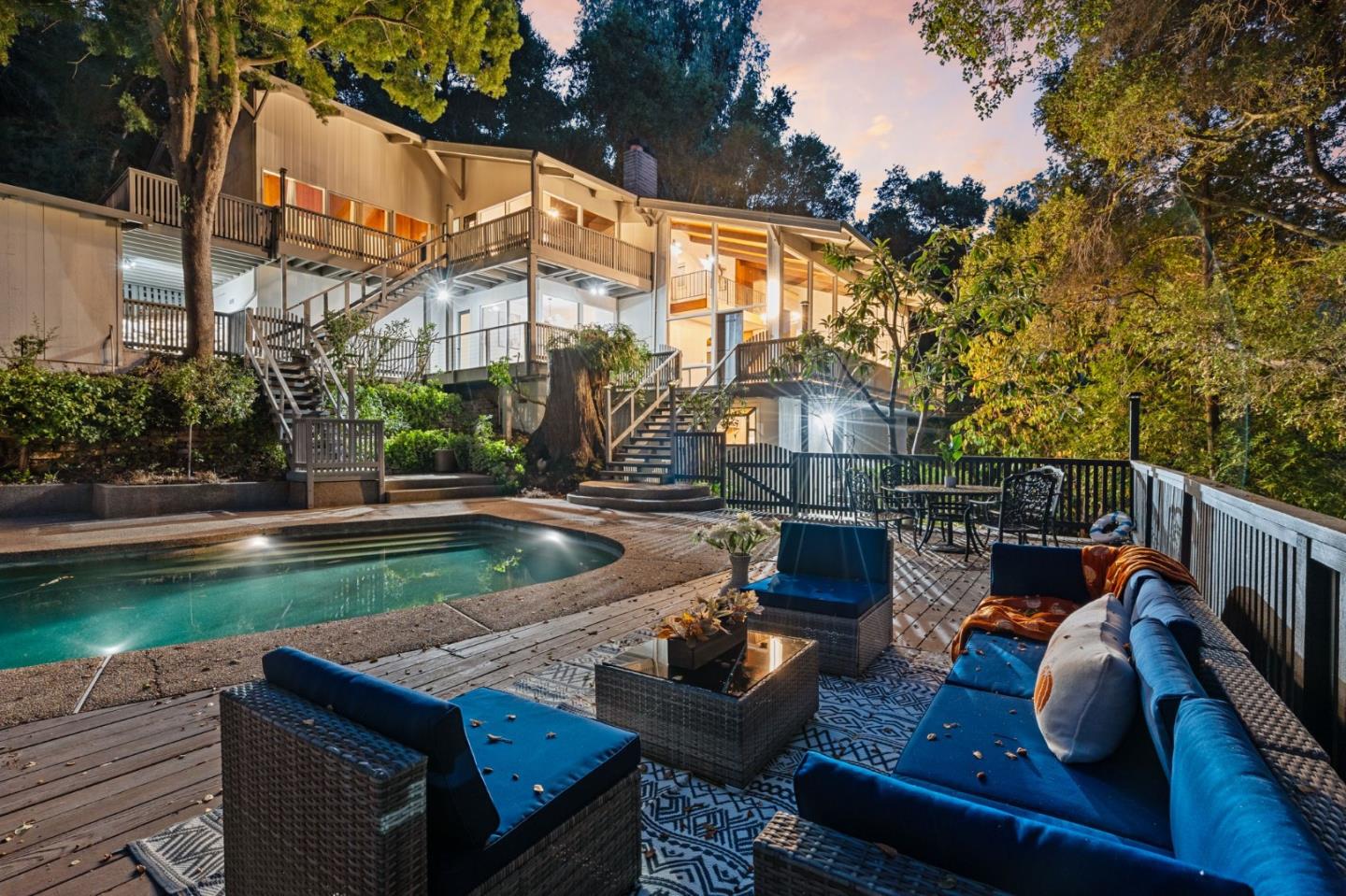 a view of a patio with couches chairs and a fire pit with wooden fence