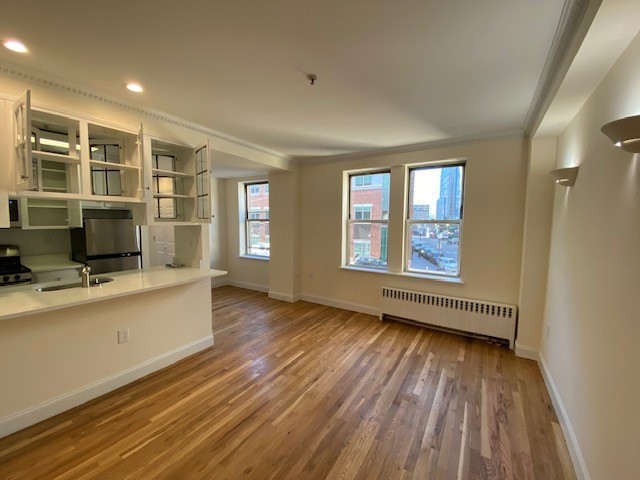 a view of a living room hardwood floor and a window