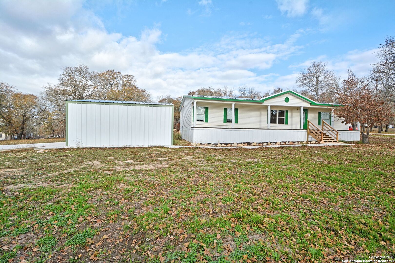 a front view of house with yard and trees around