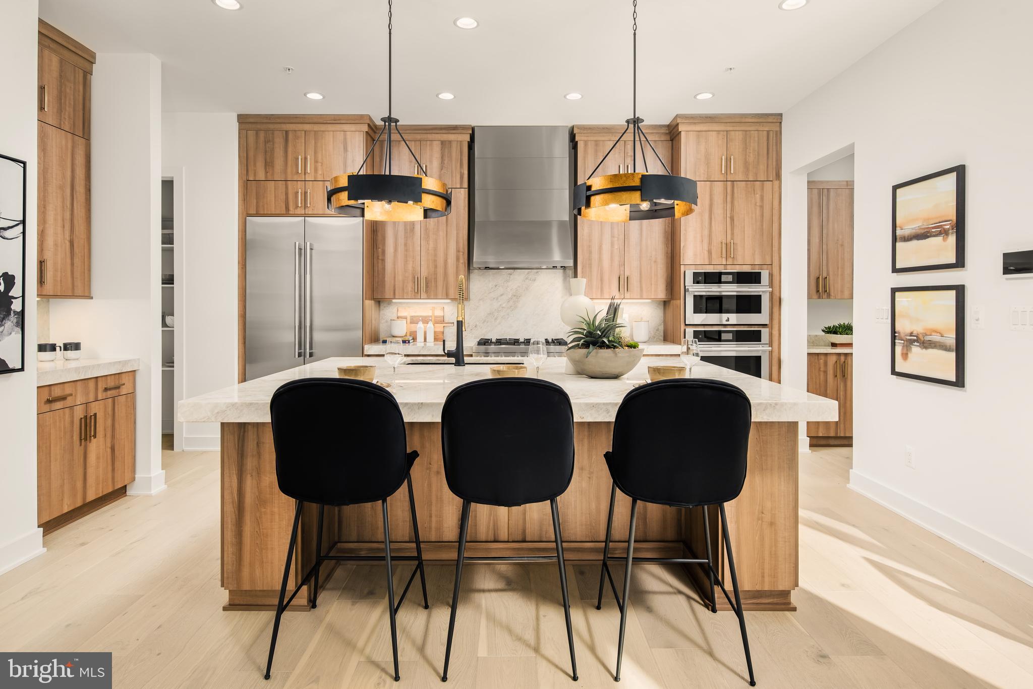 a kitchen with stainless steel appliances kitchen island granite countertop a table chairs and a refrigerator