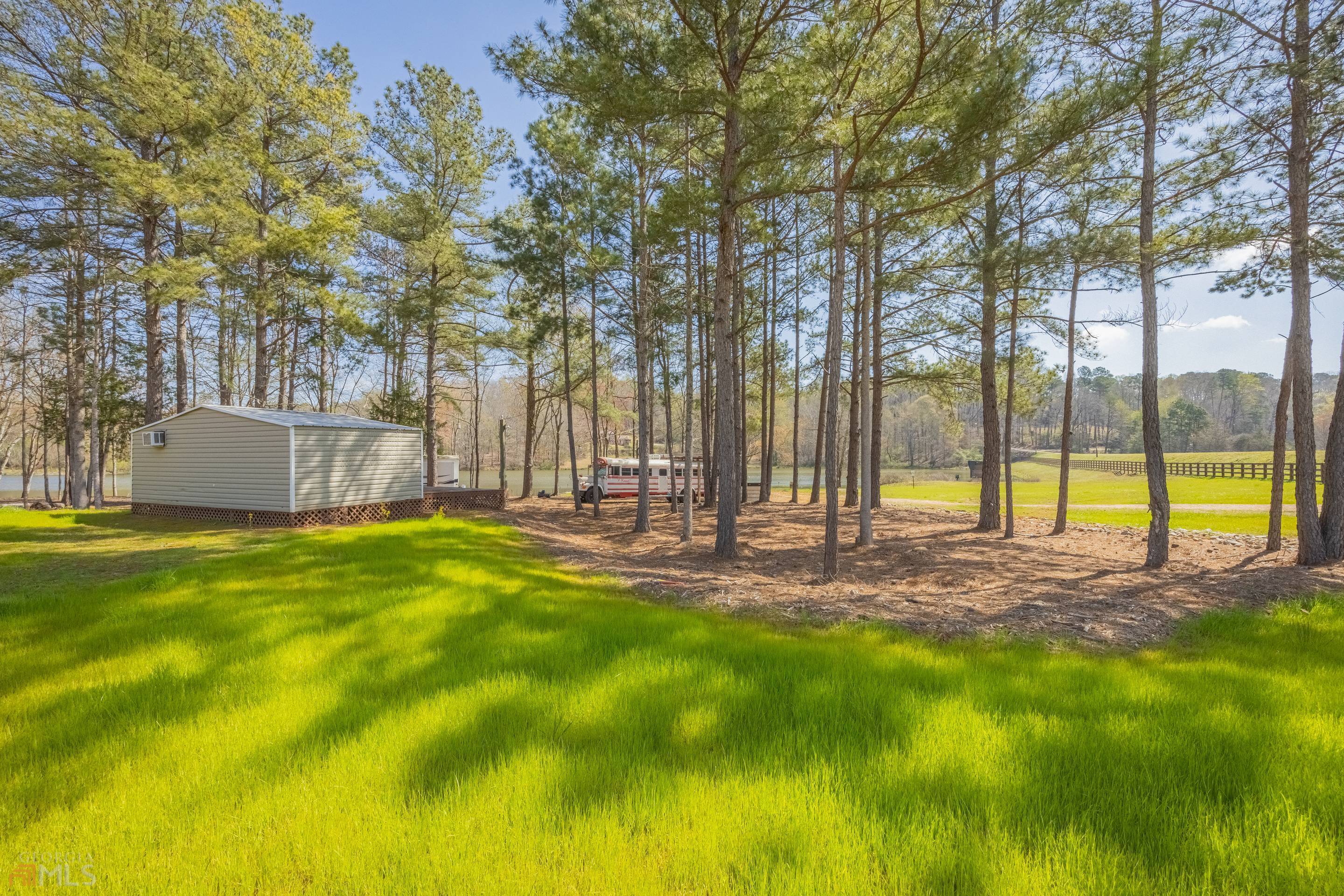 a view of yard with swimming pool and trees in the background