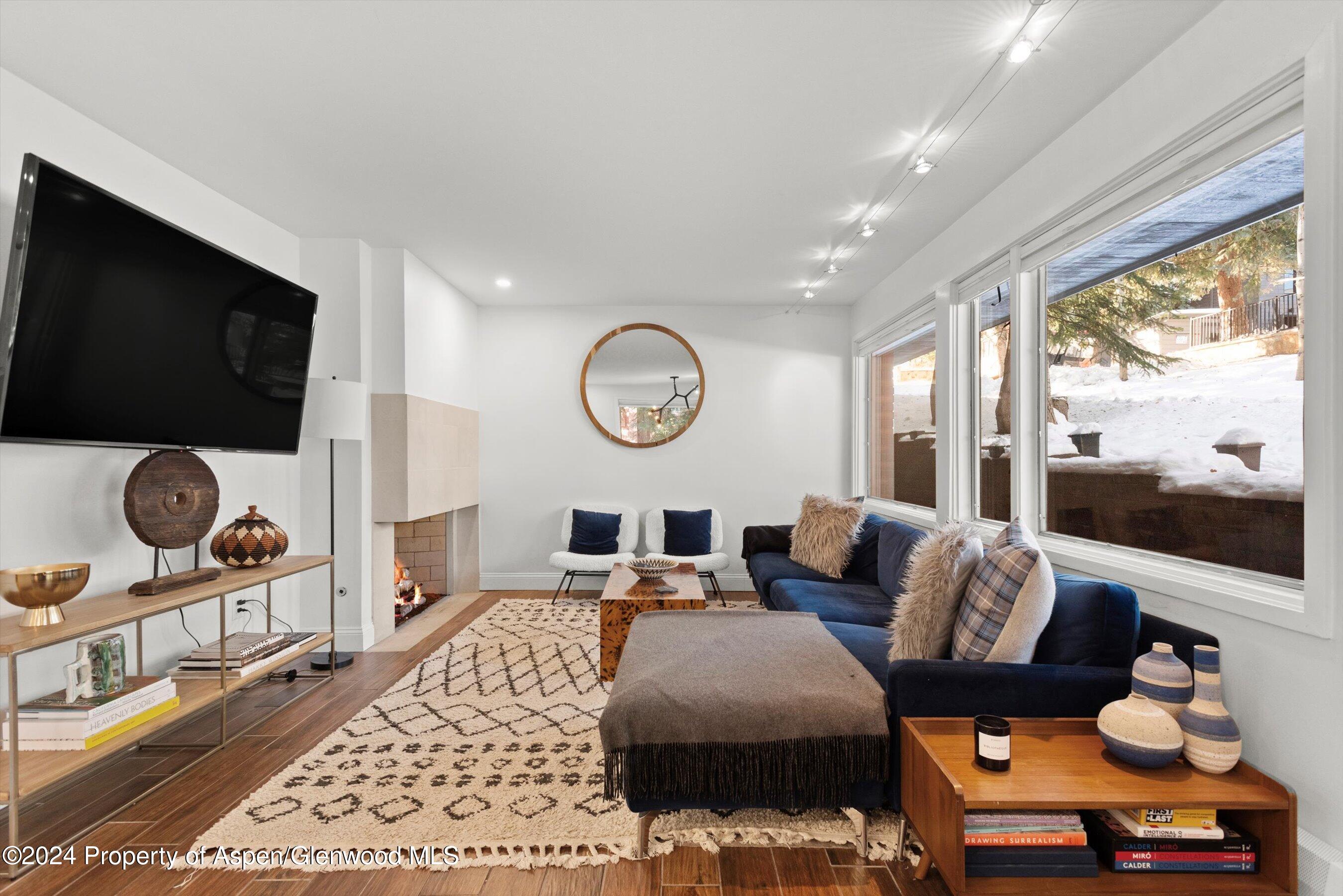 a living room with furniture a flat screen tv and a large window